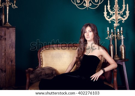 fashion photo of beautiful young woman with dark hair wears elegant black dress,posing in studio