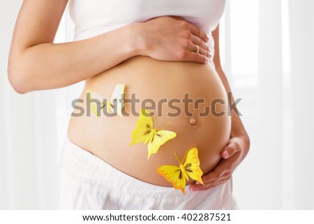Pregnant woman with butterflies on her tummy 