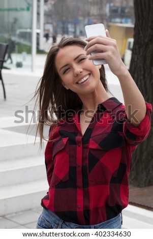 Young woman taking pictures with smart phone