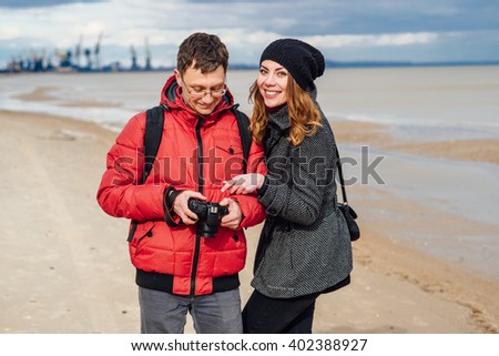 tourists happy couple walking along the beach and enjoyed being photographed on a cloudy spring day