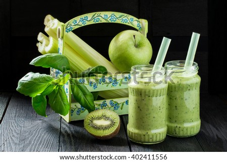 The concept of healthy eating. Ingredients for cooking in the box and jars of vitamin green smoothie on a wooden table