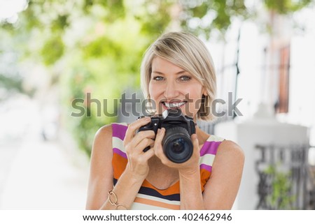 Portrait of woman with camera in city