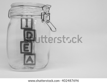 Wooden block IDEA word in the glass bottle with white background in Black and white view
