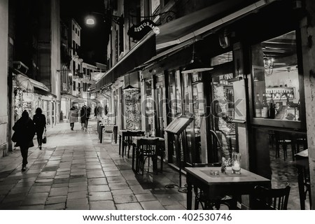 Narrow street in Venezia at night. Black and white photo.