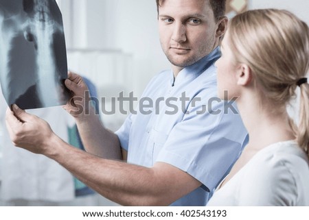 Doctor and patient looking at chest x-ray Royalty-Free Stock Photo #402543193
