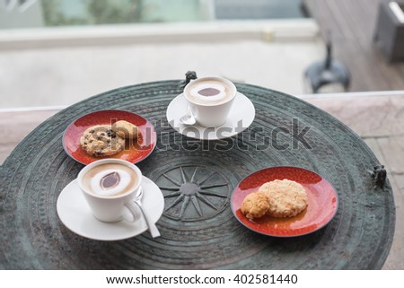 Cappuccino in white circles with cookies, anasa on a table