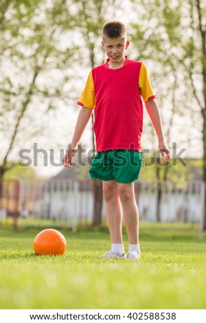 Young boy with soccer ball posing for picture