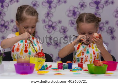 Girls sister paint eggs for Easter colors
