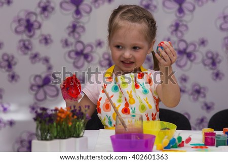 girl shows her painted eggs for Easter
