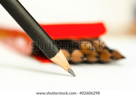 graphite pencil on a white sheet on a background of the box with pencils, macro