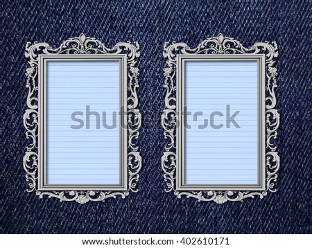 Close-up of two blank silver Baroque picture frames with aqua striped paper sheet on blue jeans fabric background