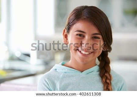 Head And Shoulders Portrait Of Hispanic Girl At Home