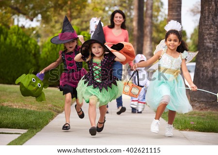 Parent Taking Children Trick Or Treating At Halloween Royalty-Free Stock Photo #402621115
