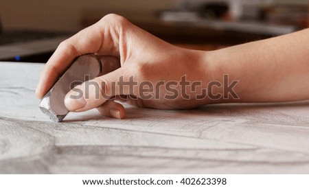 Hand holding eraser at drawing