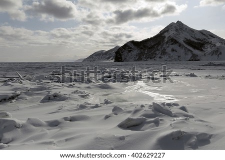 the rocks along the shore of a frozen sea