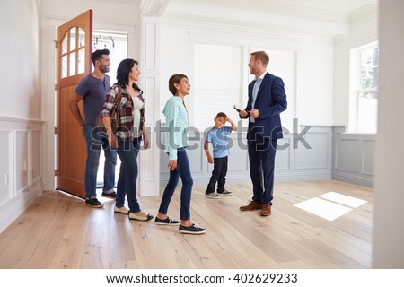 Realtor Showing Hispanic Family Around New Home Royalty-Free Stock Photo #402629233