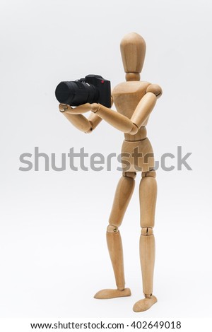 Photographer and camera/Person represented by a wooden dummy holding a photographic camera as if taking photos.