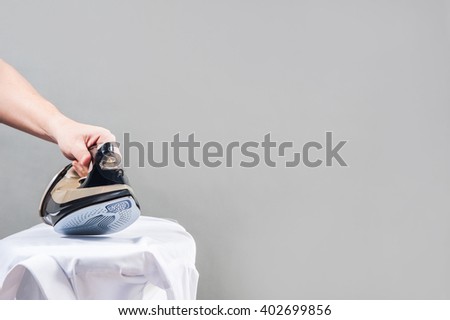 man irons white shirt / ironing
