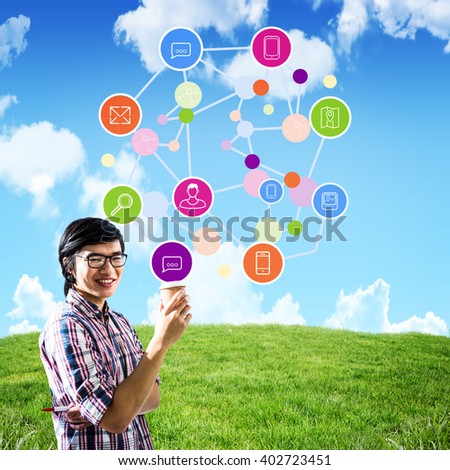 Smiling creative businessman with take-away coffee against blue sky over green field