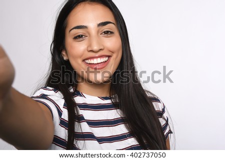 Close-up of young beautiful woman taking selfie. Isolated white background Royalty-Free Stock Photo #402737050