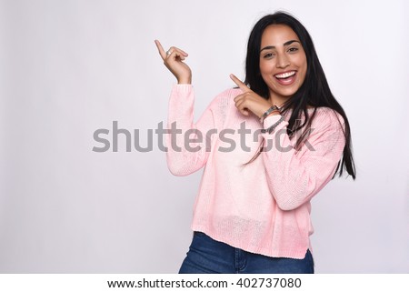 Young beautiful woman pointing at white background. Royalty-Free Stock Photo #402737080