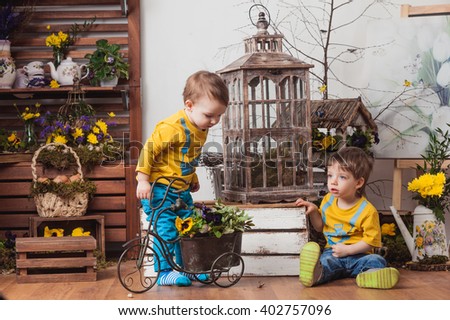 
Two brothers young boys in identical T-shirts on the background of spring colors , elegant d?cor and play .