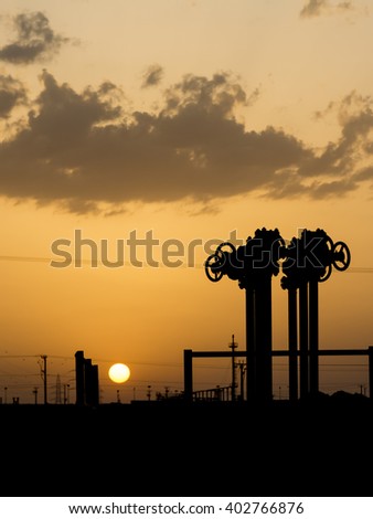 Sunset and silhouette of pipeline valves
