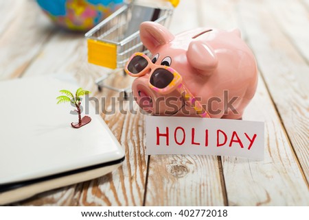 Piggy bank, laptop, globe, holiday caption