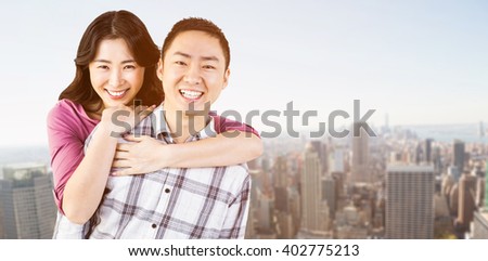Smiling man gives girl a piggy back against new york skyline