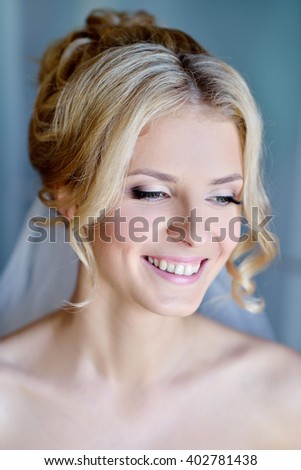 Beauty bride in bridal gown with lace veil indoors. Beautiful model girl in a white wedding dress. Female portrait of cute lady. Woman with hairstyle