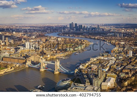 London aerial skyline view including Tower Bridge with red Double Decker Bus, skyscrapers of Canary Wharf and River Thames