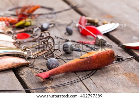 different fishing tackles and spoon on wooden board background. Concept design for freshwater outdoor active business company.