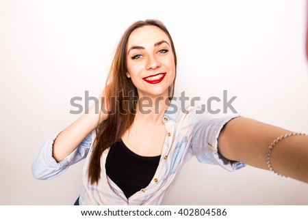 Young beautiful girl taking Selfie picture from hands  over white