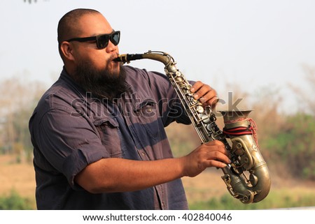 A portrait of saxophone player in the park