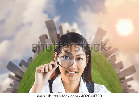 Businesswoman looking through magnifying glass against blue sky with white clouds