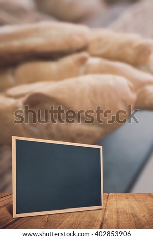 chalkboard against close up of basket with rustic baguettes