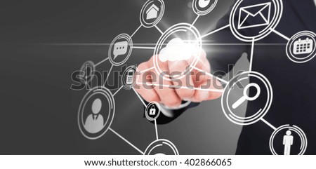 Smiling businessman in suit pointing against technology interface