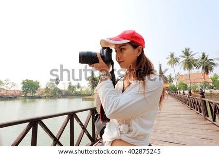 Asian woman photographer apprichiated at landscape Thailand tropical view. Image made vintage tone. 