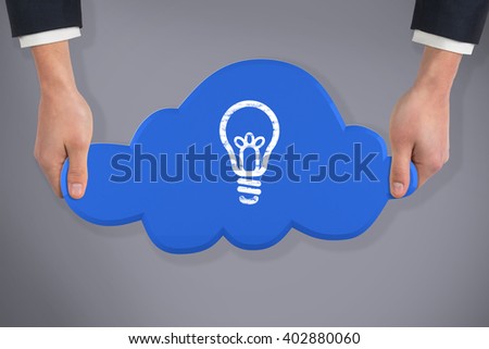 Hand holding cloud against grey background