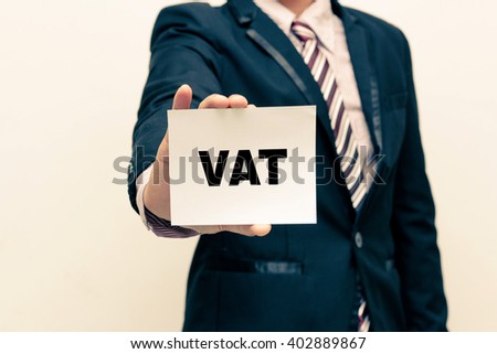 Businessman holding a card with text VAT ,  business concept.