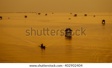 Sunrise and fisherman go to work at Bang Ta Boon bay,Phetchaburi province,Thailand,Soft focus
