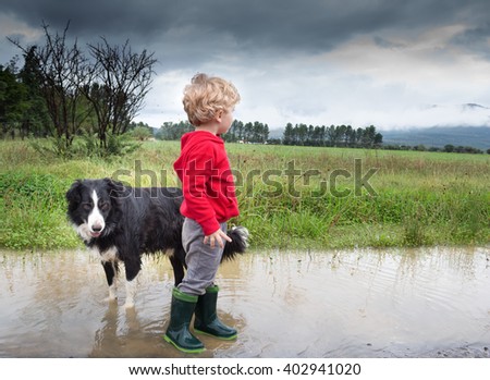 Photo of a blonde boy and his dog after the rain
