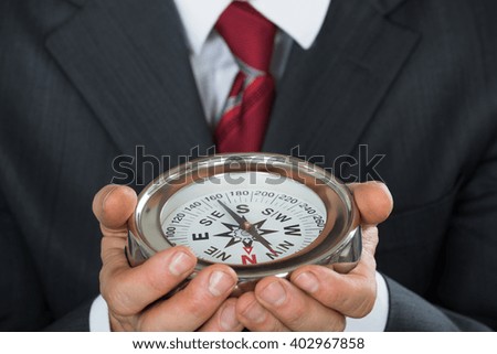 Close-up Photo Of Businessman Hand Holding Compass