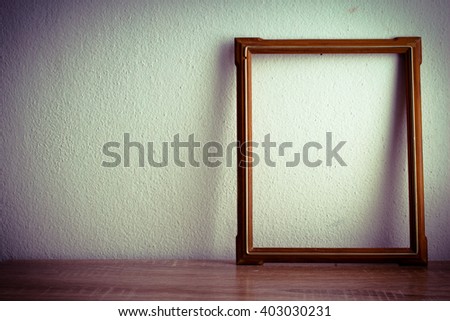 photo frame on wooden table over grunge background, Vintage style