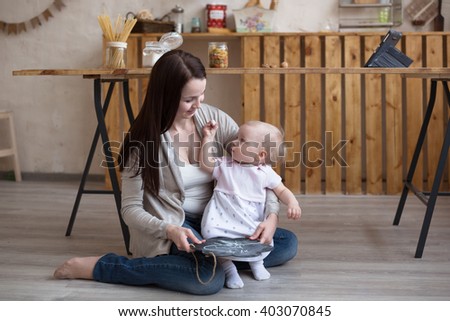 Young mother and toddler daughter  drawing  black board and chalk, lifestyle real interior