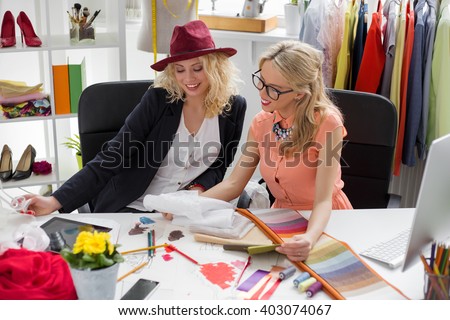 Two fashion designers looking at sketch 