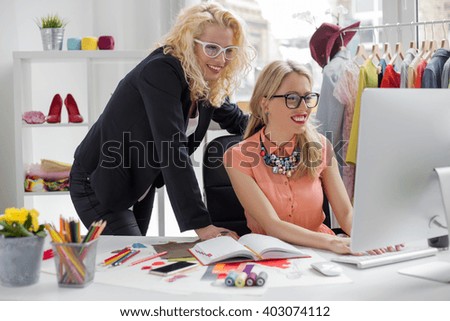 Two creative fashion designers looking at computer 