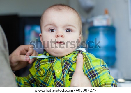 Little baby makes faces at the background of water cooler, closeup portrait, smiling, nice,  moving, pathetic