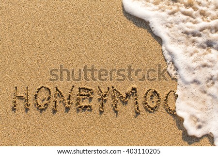 Honeymoon - drawn of the hand on the beach sand, soft surf wave.