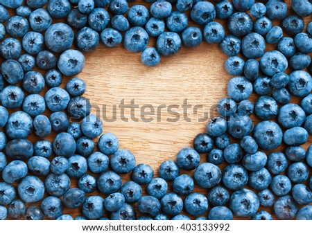 Heart shape made of premium Blueberries on wooden background. Close up, top view, high resolution product. Harvest Concept